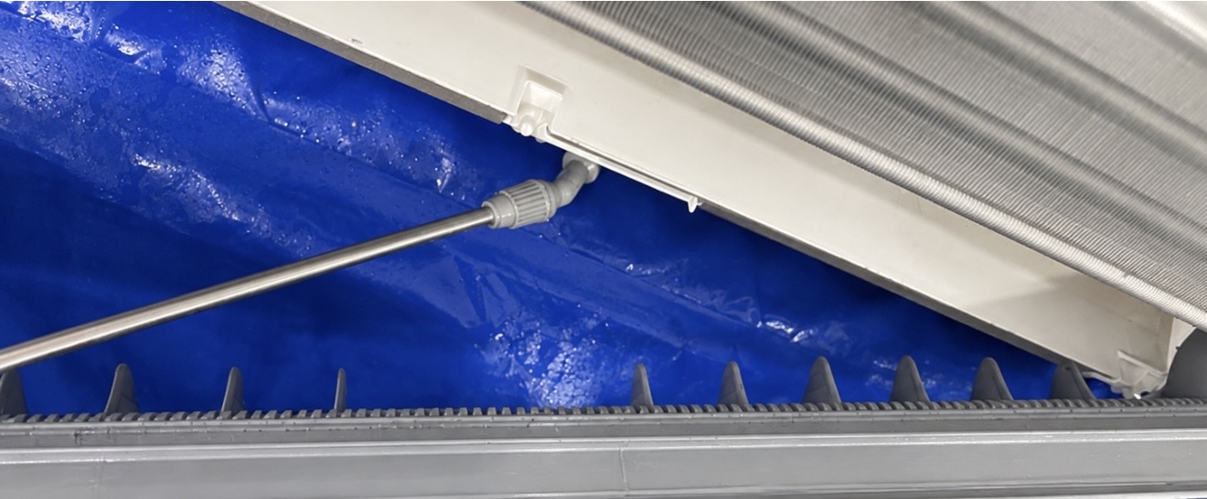 Air conditioner after the drain tray has been flushed out, with protective tarp in place