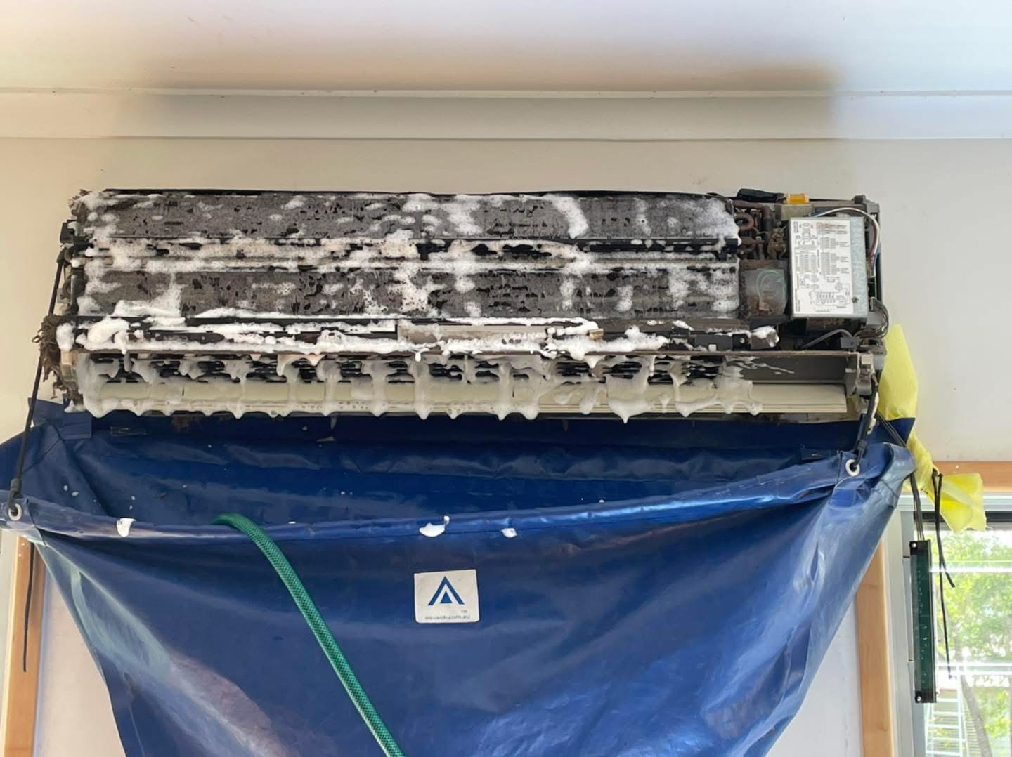 Air conditioner coil covered in cleaning foam during a deep clean
