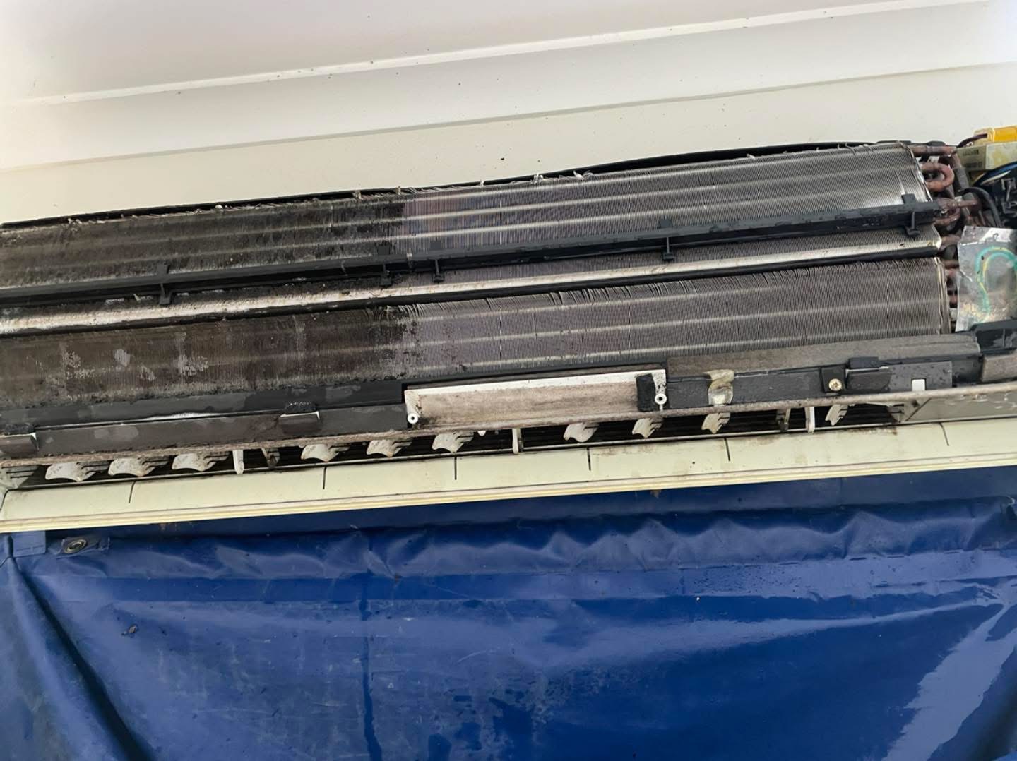 Air conditioner stripped down showing coil half cleaned