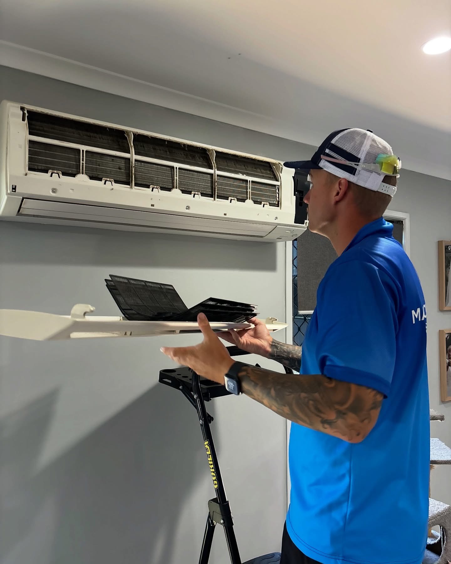 Mackay Aircon & Solar Cleaning technician removing dirty filters from a split system