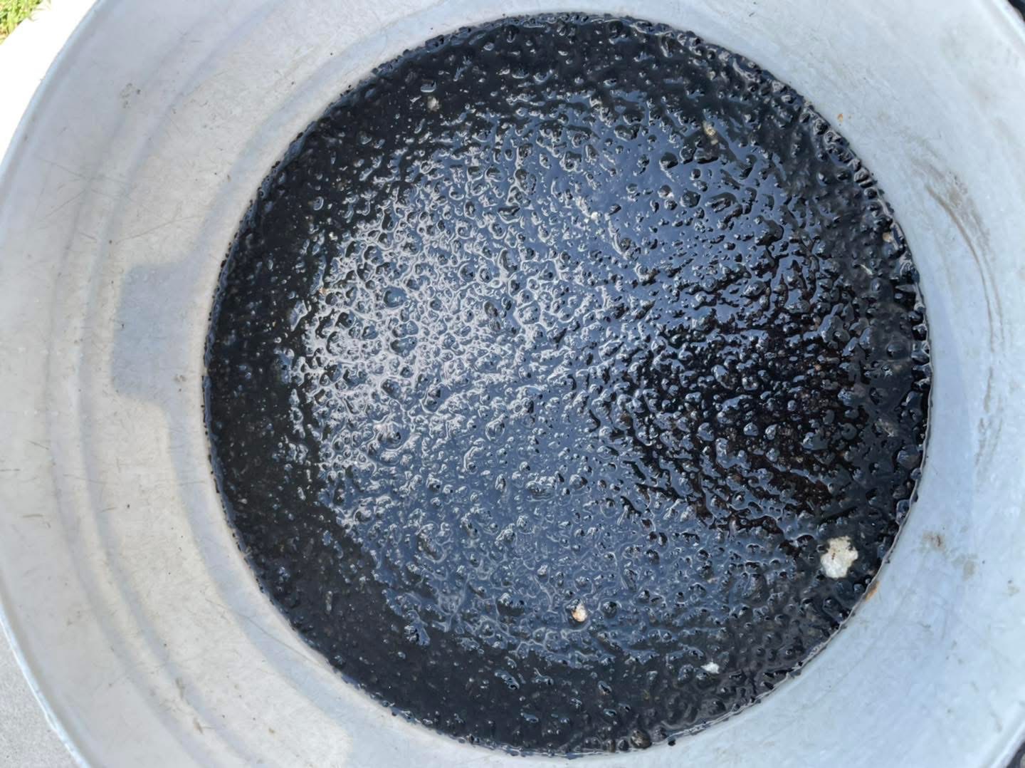 Bucket of black waste water drained from a dirty air conditioner