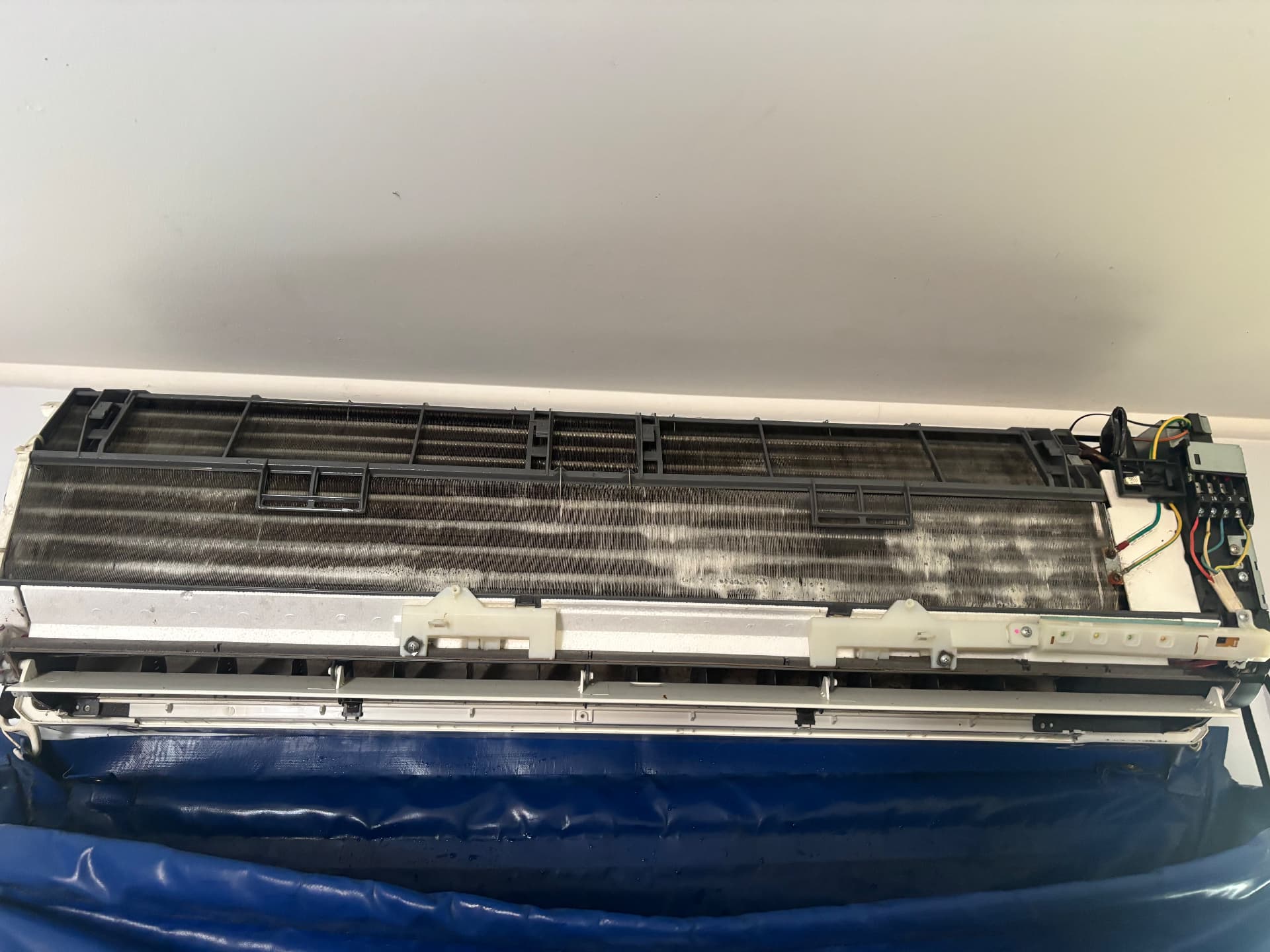 Dirty air conditioner coil covered in mould and grime before cleaning