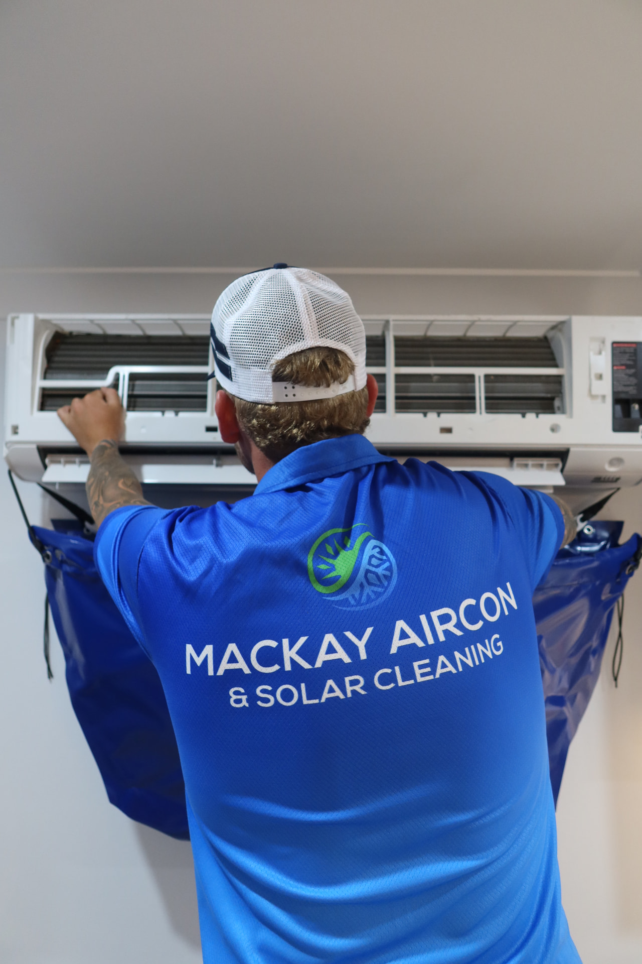 Mackay Aircon & Solar Cleaning technician servicing a split-system air conditioner