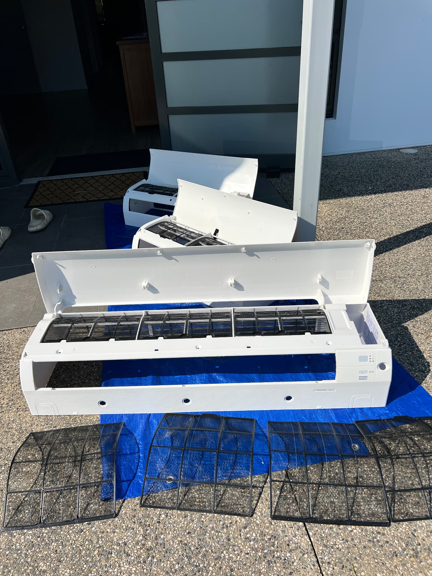 Air conditioner covers and filters removed and laid out for a full strip-down clean
